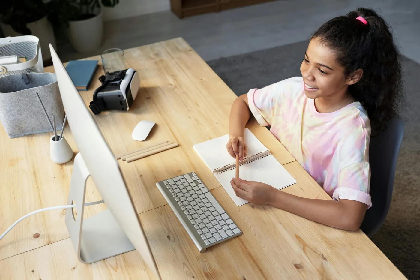 Una niña en un escritorio con una computadora, lista para una sesión en línea